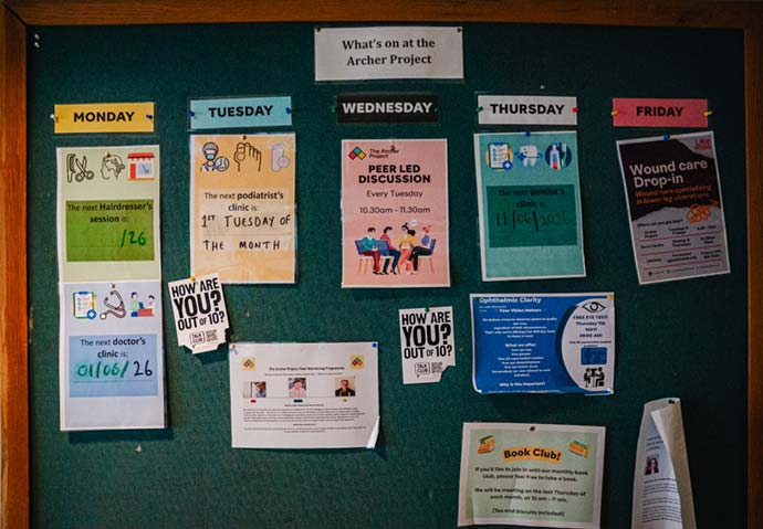 Notice board with numerous events posted including hairdressing and peer led discussions